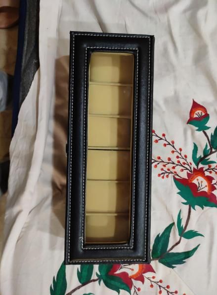 Set of gold-colored items in a black frame on a floral fabric background