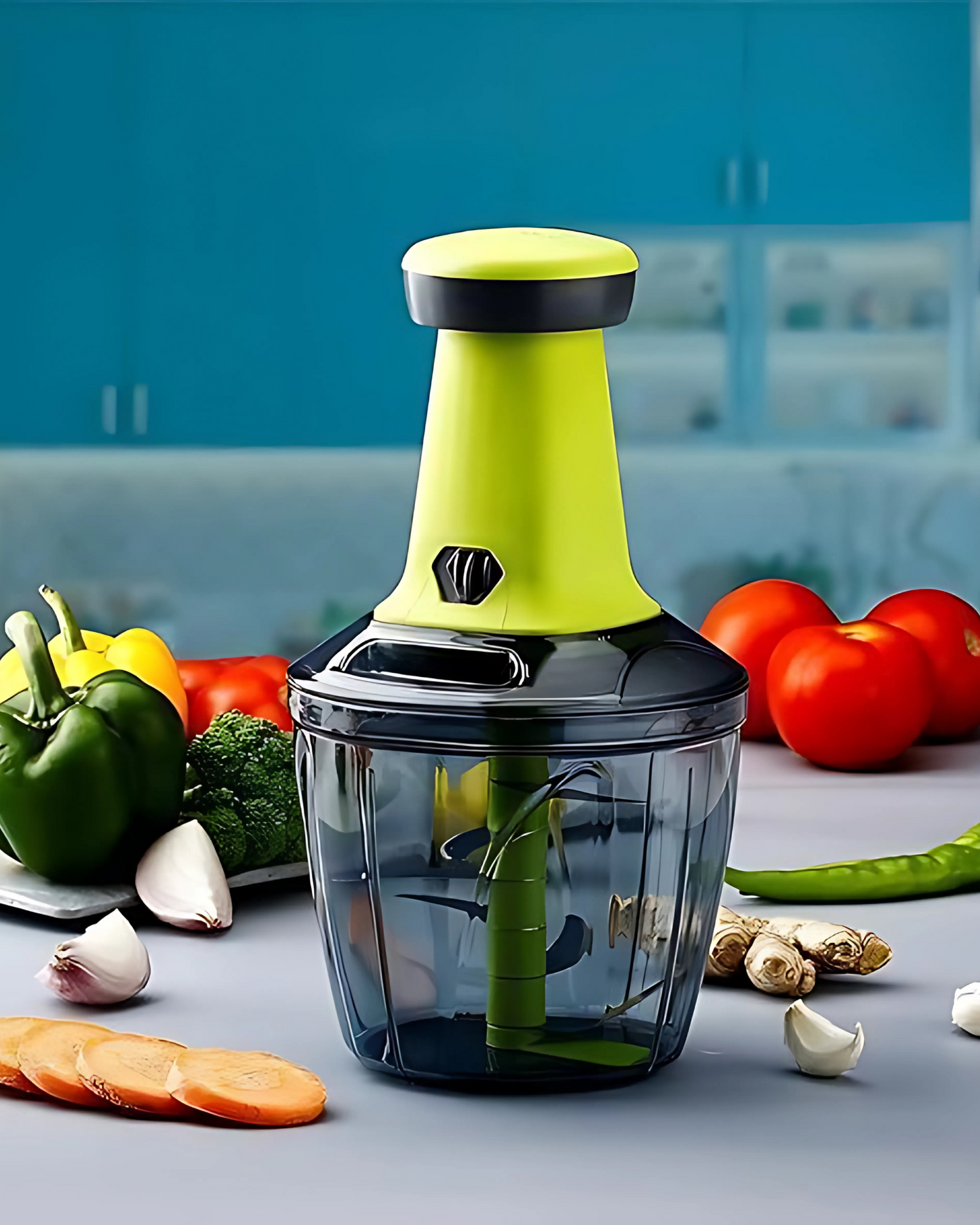 Vegetable chopper with green handle and clear container on a kitchen counter with vegetables.