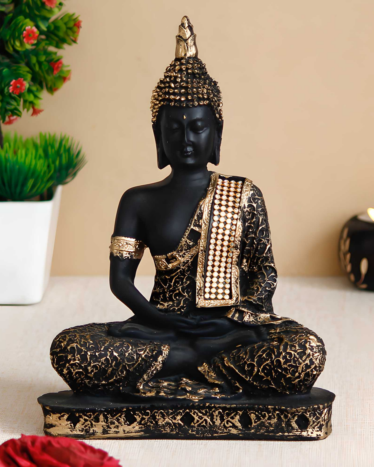 Decorative Buddha statue with black and gold details on a beige surface.