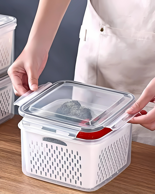 Person holding a white storage container with a transparent lid on a wooden surface.