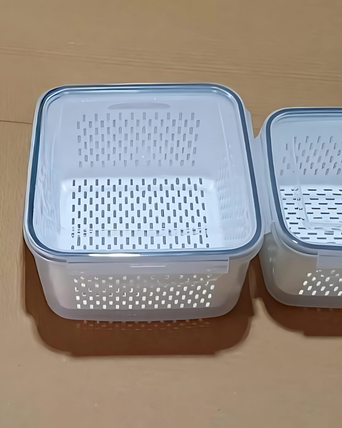 Two plastic containers with perforated lids on a beige surface