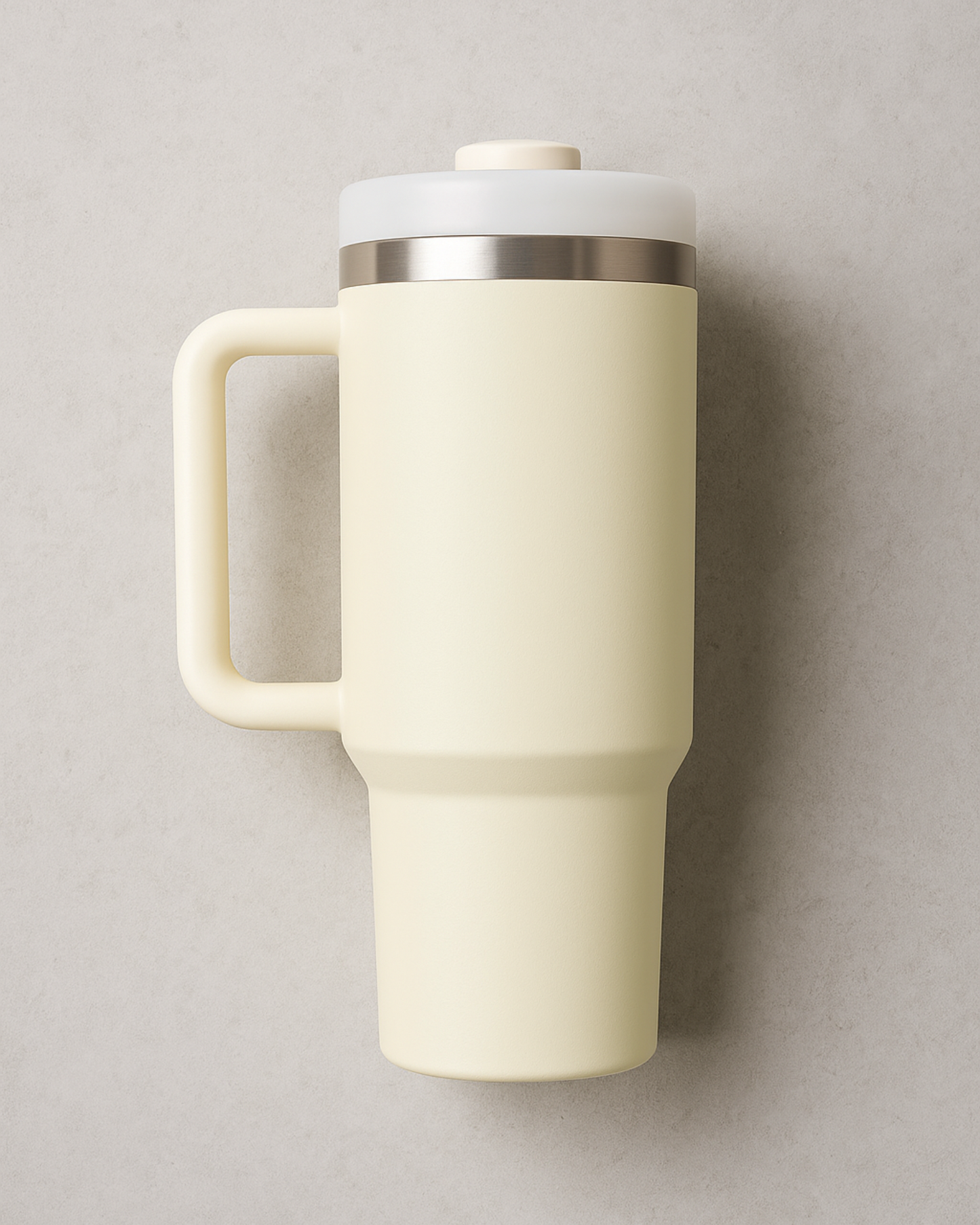 Beige travel mug with handle and lid on a neutral background