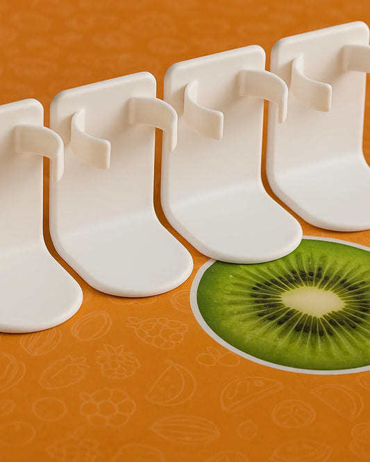 White fruit corer on an orange background with a sliced kiwi