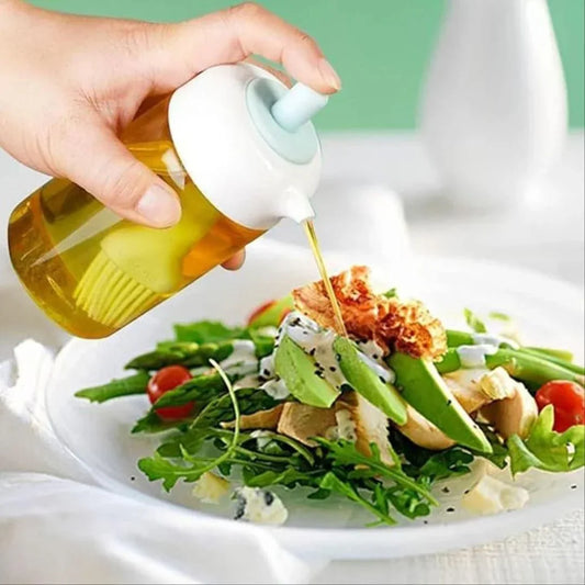 Hand using a bottle to drizzle oil over a salad on a white plate.
