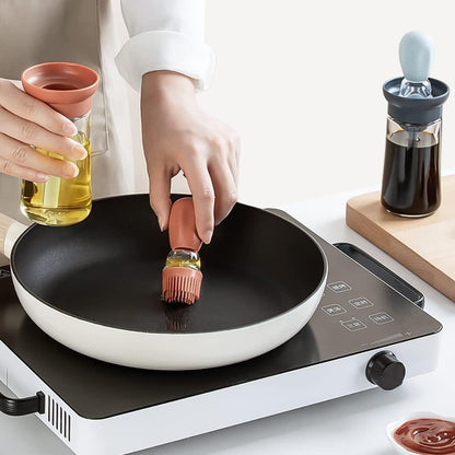 Person brushing oil on a frying pan with a small bottle of oil and a brush in the background.