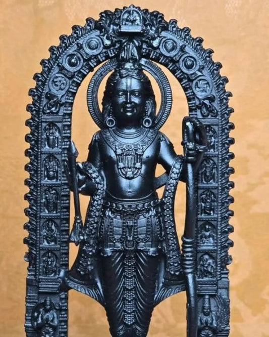 Decorative black statue of a deity with intricate details on a beige background