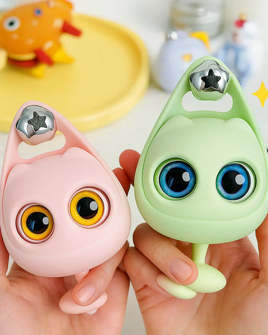 Two small, colorful toys with large eyes held in hands against a blurred background.