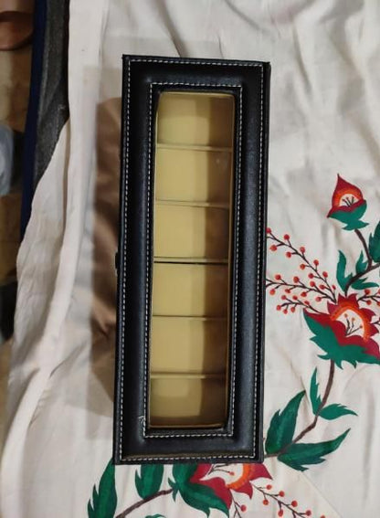 Set of gold-colored items in a black frame on a floral fabric background