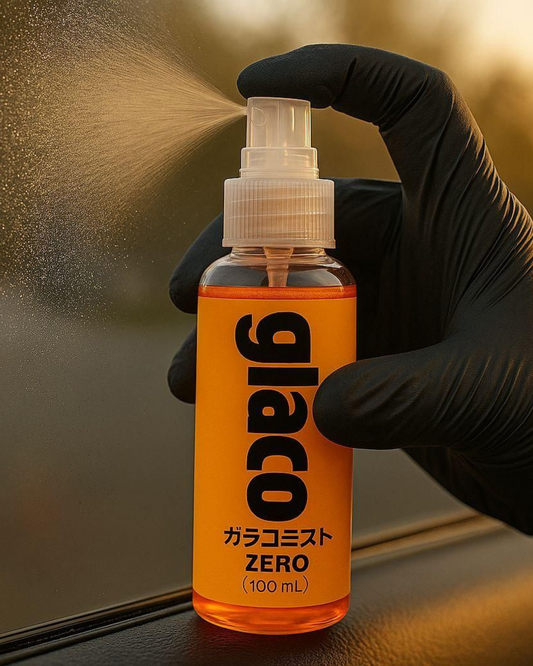 Orange spray bottle labeled 'glaco' with a gloved hand holding it, spraying onto a surface.