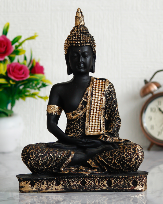 Decorative Buddha statue with black and gold details on a white surface.