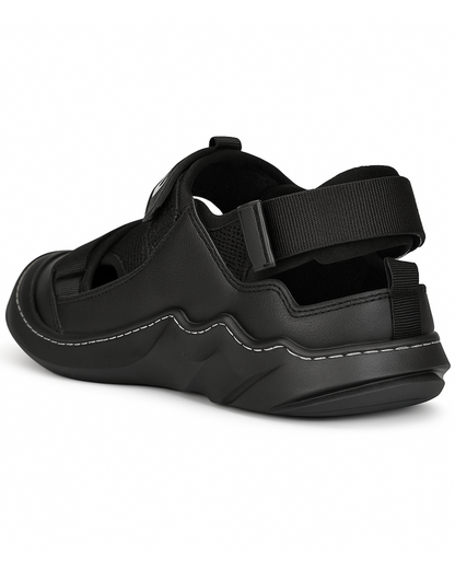 Black sandal with thick sole and adjustable straps on a white background