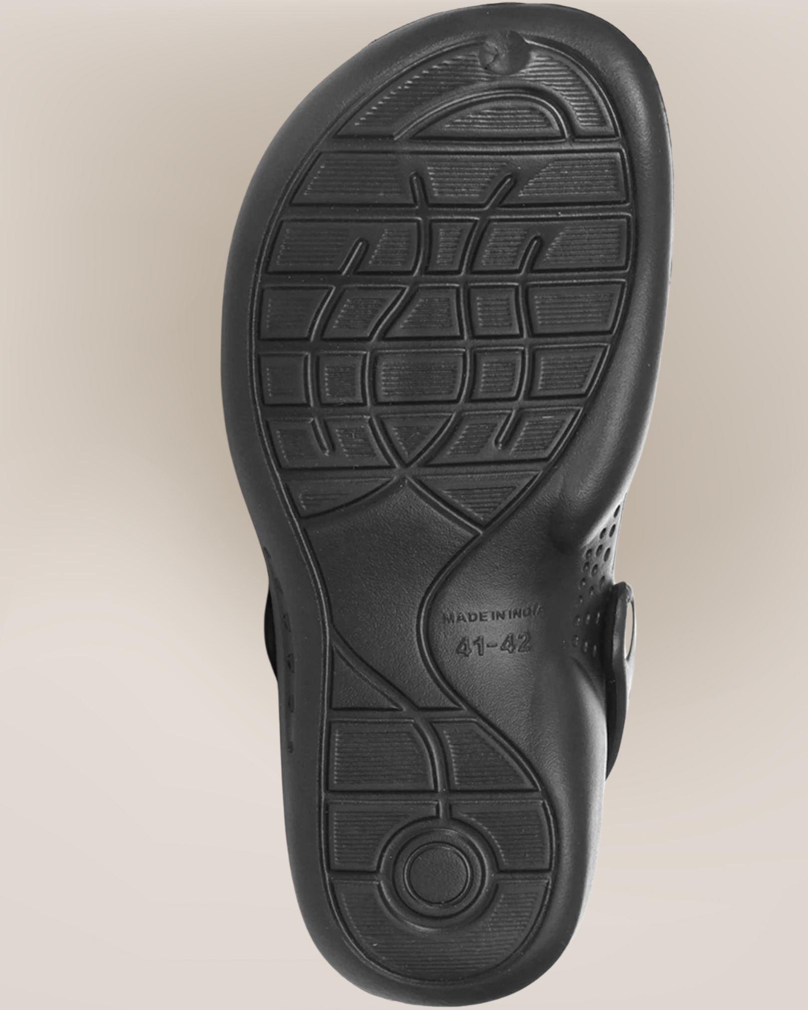 Black sandal sole with tread pattern on a beige background