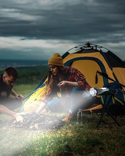 Two people camping outdoors with a tent and cooking equipment.
