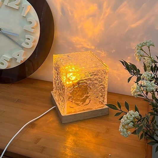 Decorative lamp on a wooden surface with a clock and plant in the background