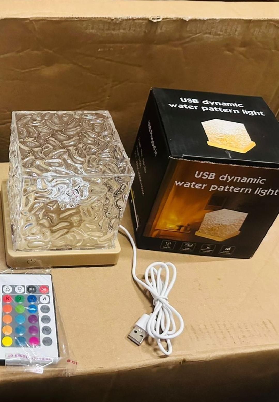 USB dynamic water pattern light with packaging, remote control, and USB cable on a cardboard surface.