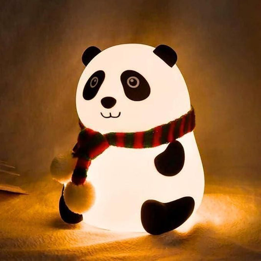 Panda-shaped night light with a red and green striped scarf on a warm background