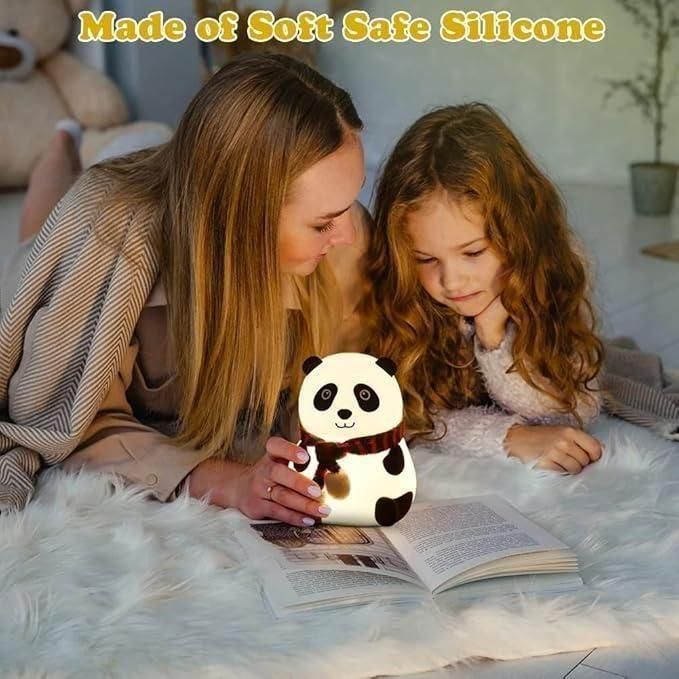 Woman and child reading with a panda-shaped night light on a soft surface.