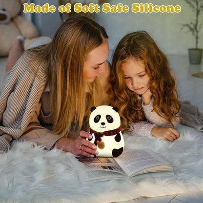 Woman and child reading with a panda-shaped night light on a soft surface.